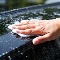 Hand-washing a glossy car exterior